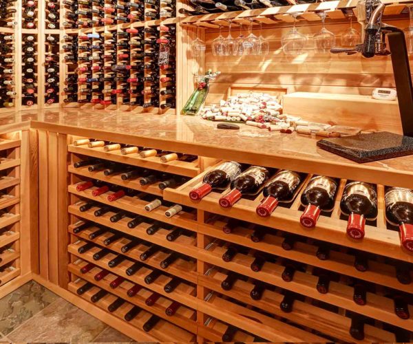 Cave à vin avec des bouteilles de vin rouge et blanc et des verres à vin au restaurant la table de trois à Bordeaux