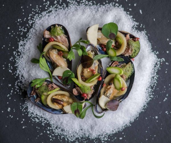 Sur du gros sel des huîtres gratinées avec quelques condiments au restaurant la table de trois à Bordeaux